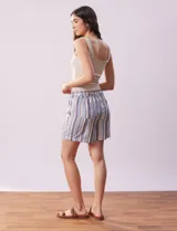 Short color crema con finas rayas verticales grises, pretina elastizada con cordón de ajuste, bolsillos delanteros y traseros.