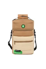 Mochila cilíndrica tipo matera, con dos compartimentos separados por cierre. El cuerpo superior es de material liso color camel y el inferior es acolchado color beige. Presenta parches circulares con motivos de naturaleza y una etiqueta verde con el texto "EXPLORE YOUR WORLD: Discovery".