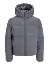 Campera puffer con capucha ajustable, cierre frontal con cremallera y bolsillos laterales. Presenta un diseño acolchado en color gris oscuro con logo sutil bordado en el pecho.