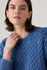 Sweater azul de punto trenzado con cuello redondo y mangas largas.
