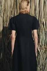Vestido midi de cuello redondo y manga corta abullonada con terminación elástica. Presenta un diseño de corte entallado en el torso con falda evasé y cierre de cremallera oculta en la espalda.