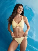 Top de bikini halter, color lila pálido con estampado de pequeños motivos en amarillo claro. Presenta un nudo central ajustable y tirantes finos que se anudan en la espalda y el cuello.
