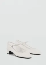 Zapato de malla blanca con tacón bloque, tejido semitransparente, cierre de hebilla y punta redonda.