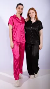 Camisa de manga corta con cuello camisero y botones nacarados. La tela es negra con un patrón de rayas verticales en relieve, con un acabado satinado.