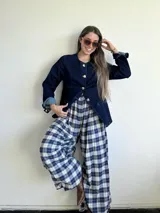 Pantalón de corte amplio y holgado, tipo babucha, confeccionado en franela con estampado de tartán escocés en tonos azul, blanco y negro. Presenta cintura elástica para un ajuste cómodo y versátil.