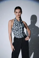 Top sin mangas con cuello halter y diseño ajustado al cuerpo, con estampado de piel de serpiente en tonos grises y negros.