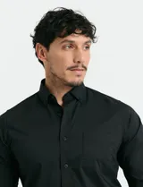 Camisa de manga larga color verde oscuro, con cuello button-down, cierre frontal de botones y bolsillo en el pecho.