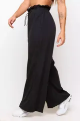 Conjunto deportivo de dos piezas compuesto por un buzo cropped de cuello alto con cordón ajustable y un pantalón estilo clochard de corte holgado con cintura elástica regulable y bolsillos laterales. Ambas prendas están confeccionadas en tejido técnico ligero con acabado suave al tacto.