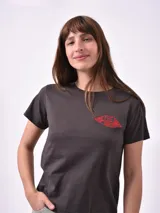Remera de algodón color gris oscuro, con cuello redondo y mangas cortas. Presenta un estampado frontal pequeño en el pecho con forma de labios rojos que contiene la frase 'Save the drama for your mama'.