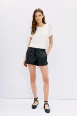 Short negro de efecto cuero con cintura elástica ajustable mediante cordón y bolsillos laterales.