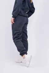 Pantalón de jogging negro con cintura elástica y cordón ajustable. Estampado con la palabra "GRAPHITE" en blanco en la pierna izquierda.