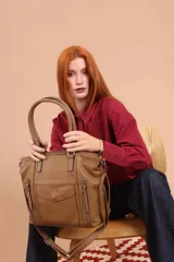 Cartera tipo tote de diseño estructurado en símil cuero, con doble asa rígida y correa regulable. Presenta múltiples bolsillos frontales con cierre y solapa, ofreciendo un estilo versátil y espacioso.