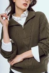 Sweater de tejido de punto color bordó, con cuello alto, cierre frontal parcial y mangas largas.