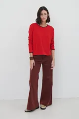 Remera de manga larga en color azul marino, confeccionada en tejido suave. Presenta un delicado detalle de bordado festoneado en color blanco tanto en el cuello redondo como en los puños, aportando un toque distintivo a esta prenda básica.