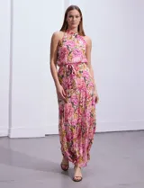 Vestido largo de gasa estampada con flores rosas, amarillas y verdes, marca Julia Jordan. Tiene escote halter, cintura elastizada con lazo de ajuste, abertura en la espalda con botones y forro interno a tono.