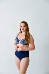 Conjunto de bikini compuesto por un top con aro y diseño estampado en tonos azules, y una bombacha de tiro alto en color azul liso. Confeccionado en lycra, ofrece soporte para el busto y un calce cómodo.