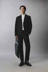 Pantalón de traje slim fit color negro, confeccionado en tejido con viscosa, con bolsillos frontales, bolsillos traseros de doble vivo y raya marcada en las piernas. Cuenta con cierre frontal con cremallera y botón.
