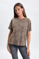 Remera de manga corta con cuello redondo y estampado animal print en tonos tostado y marrón.