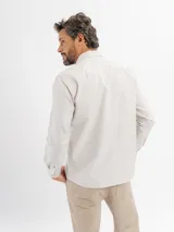 Camisa de manga larga con estampado de cuadros vichy en tonos celestes y blancos, con cuello abotonado.