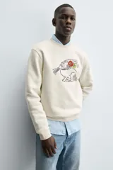 Sudadera de cuello redondo y manga larga con calce relajado. Presenta un bordado frontal de un conejo con flores y detalles en contraste, con terminaciones en rib en puños y ruedo.