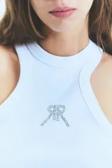 Musculosa blanca de morley con cuello redondo y sisas anchas. Isologo de la marca con tachas en el frente.