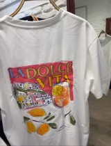 Remera blanca de manga corta y corte holgado con un estampado frontal que incluye una botella de vino, una copa de vino y la palabra "VINO" escrita al revés.