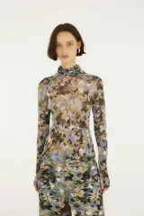 Top de tul estampado con diseño floral, cuello alto y mangas largas, de corte ajustado y tejido semitransparente.