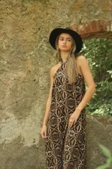 Vestido largo de corte recto con estampado abstracto en tonos marrón y beige, cuello halter y espalda descubierta.