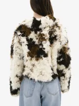 Chaqueta corta de piel sintética con estampado en tonos blanco, marrón y negro, con cierre frontal con gancho metálico.