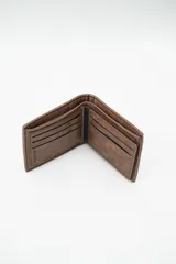 Billetera de hombre color marrón con acabado texturizado y costuras blancas en contraste. Presenta un diseño bifold con un detalle rectangular en color negro en el frente.