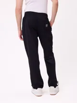 Pantalón tipo babucha de algodón y poliéster en color marrón, con cintura elástica, bolsillos laterales y logo de la marca bordado en la pierna izquierda.