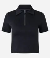 Blusa tipo polo de manga corta, color negro, con cierre frontal en el cuello y textura acanalada. Confeccionada en tejido seamless.