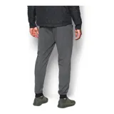 Pantalón de jogging Under Armour, color gris jaspeado, con cintura elástica ajustable con cordón, puños en los tobillos y bolsillos laterales con cierre. Presenta el logo de la marca estampado en la pierna derecha.