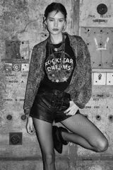 Remera de algodón color negro con estampa frontal circular que incluye la frase 'Rockstar Dreams' y estrellas decorativas.