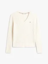 Sweater de punto trenzado color blanco de Tommy Hilfiger, con cuello en V, mangas largas y detalles acanalados en puños y dobladillo. Presenta el logo de la marca bordado en el pecho.