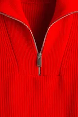Buzo de punto acanalado en color rojo, con cuello elevado y cierre frontal parcial. Diseño de corte holgado con mangas largas y puños rectos.
