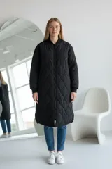 Camperón largo de estilo bomber, color negro, con diseño acolchado de rombos, cierre frontal completo y puños elásticos acanalados.