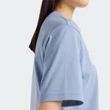 Remera celeste de corte cropped, con cuello redondo y mangas cortas. Estampado frontal con el logo de New Balance Athletics en blanco.