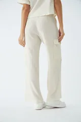 Pantalón cargo de tiro alto y corte recto, confeccionado en viscosa con textura arrugada. Cuenta con bolsillos laterales, cierre de cremallera y botones, y presillas para cinturón.