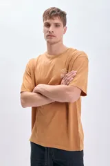 Remera color ocre de corte amplio con estampa en la espalda que incluye un plato de ramen, palillos y texto en inglés y japonés.