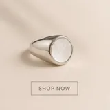 Anillo de acero quirúrgico de diseño esclavo con una incrustación circular de nácar en el centro.