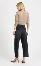 Jean de tiro alto con corte ancho y pierna recta, confeccionado en denim de lavado oscuro. Presenta costuras horizontales en la parte frontal de las rodillas, bolsillos traseros, cierre frontal con cremallera y botón, y dobladillo deshilachado.