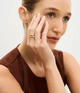 Anillo femenino de metal con diseño entrelazado y acabado de baño mixto en tonos dorado, plateado y rosado.