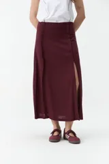 Falda midi de lino color beige, de tiro alto y corte recto, con abertura delantera y cierre cruzado sutil.