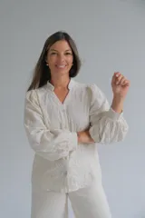 Blusa de color beige con cuello mao y cierre frontal de botones. Presenta mangas largas abullonadas con puños ajustados y un diseño con bordados en relieve de patrones orgánicos en toda la prenda.