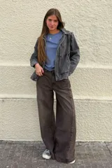 Cazadora de denim en tono gris lavado, con diseño de costuras marcadas, cuello camisero, cierre frontal con botones y bolsillos laterales.