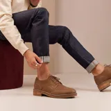 Zapato tipo brogue de cuero vacuno color marrón, con cordones, suela de madera y detalles de perforaciones decorativas en la puntera y laterales.