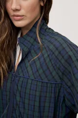 Campera liviana de calce relajado con estampado a cuadros en tonos de azul y verde. Cuenta con cuello alto, cierre frontal y mangas largas.