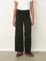 Jean de corte wide leg en color negro, con cintura alta ajustable mediante lazo y costuras verticales decorativas en el frente.