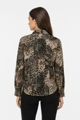 Camisa de poliéster con estampado animal print, cuello clásico, cierre frontal con botones y mangas largas con puños abotonados.